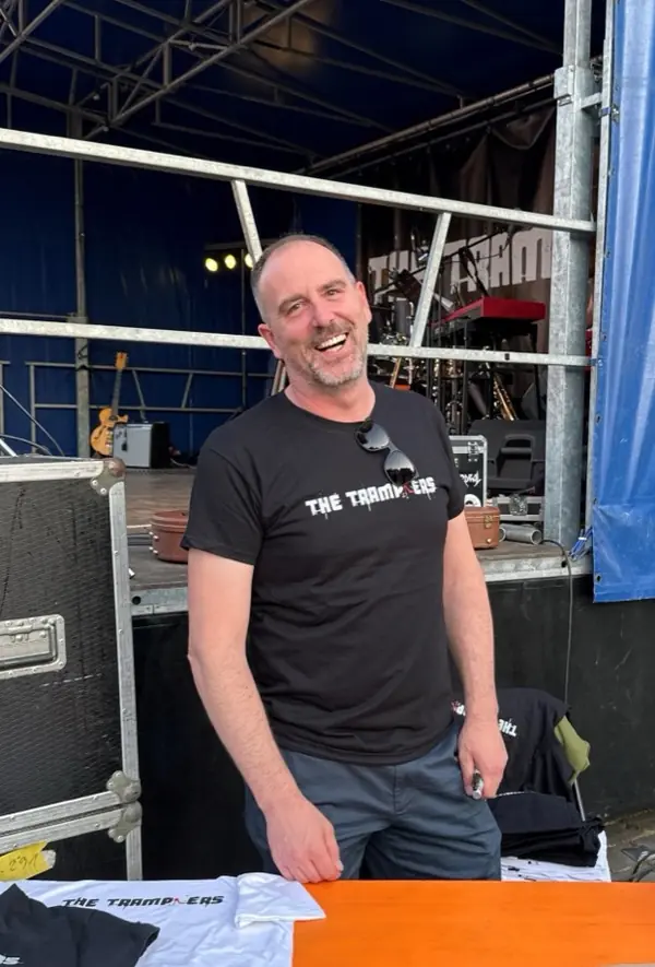 Bandmanager Bart in een Tramplers-T-shirt bij het podium